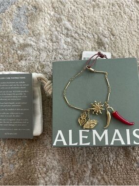 Alemais Gold-Tone Charm Bracelet with Red Horn and Sun Motif